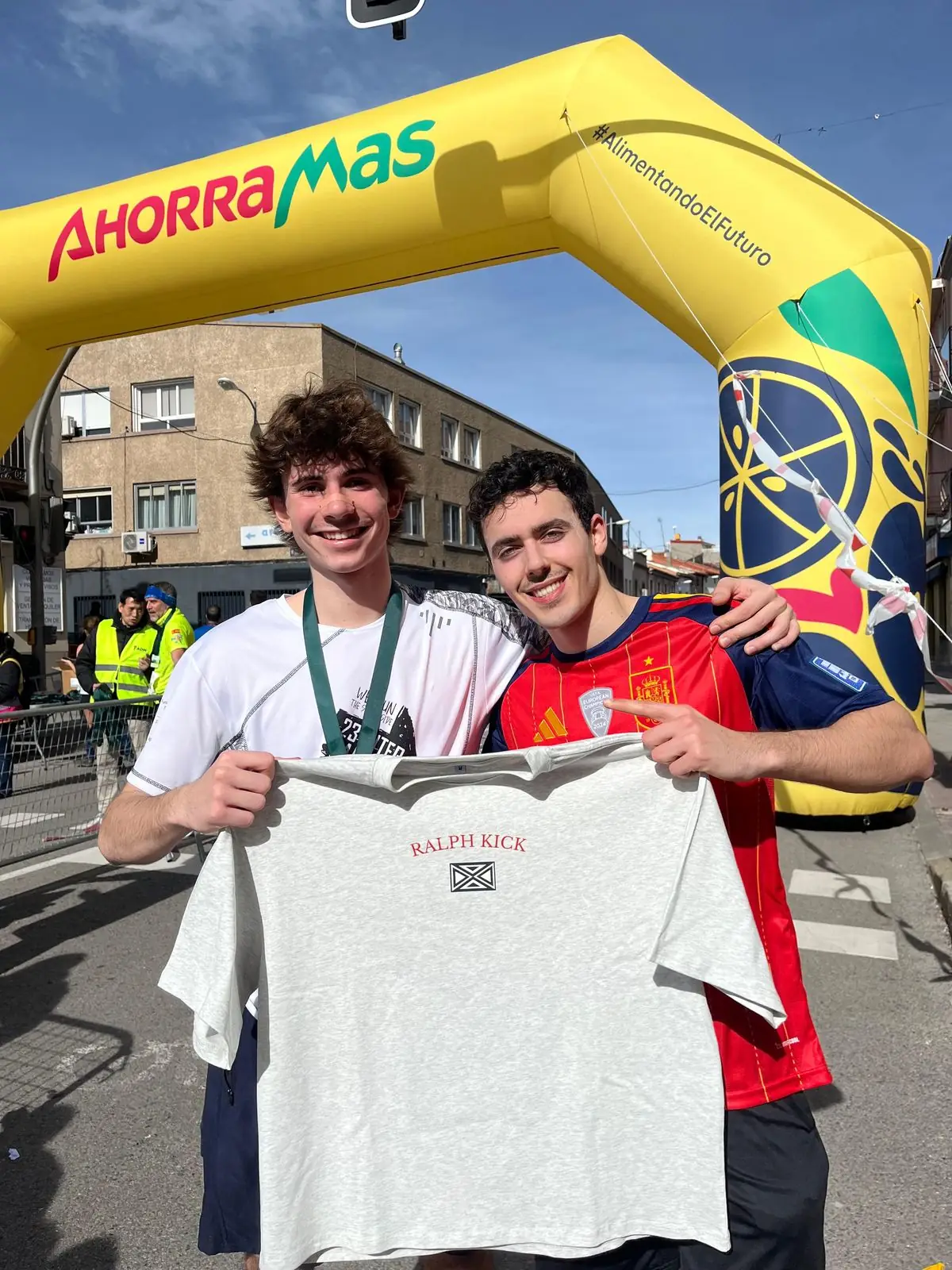 Two friends holding a RalphKick tee after a half-marathon