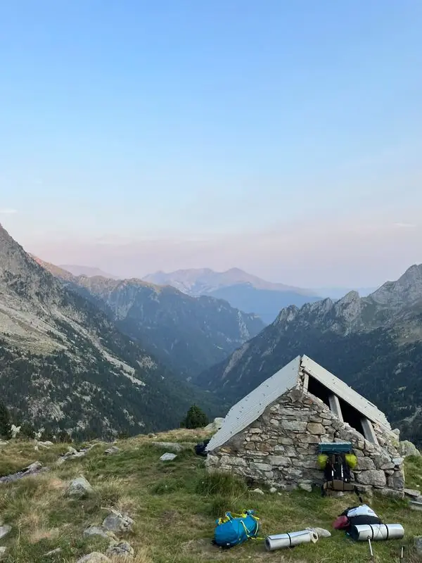 Mountain hut in a green valley at dusk